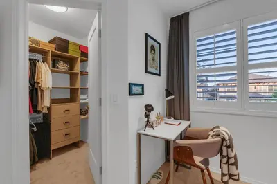 a white room with a desk and a closet at 1P Culture - Sara in Calgary