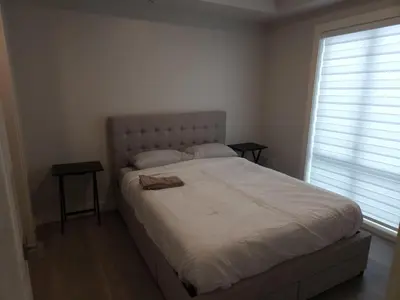 a bedroom with a large bed with a large window at Central 2-Bedroom Townhouse Oak st in Vancouver