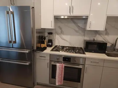 a kitchen with stainless steel appliances and white cabinets at Central 2-Bedroom Townhouse Oak st in Vancouver