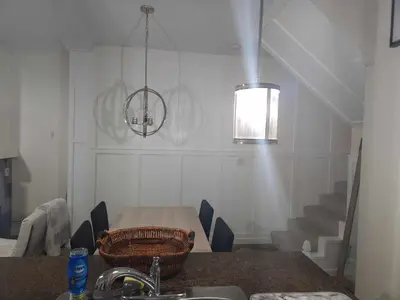 a dining room with a table and a light fixture at Central Townhouse Richards Street in Vancouver
