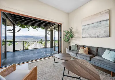 a living room with a couch and a large window at Full House with Amazing Okanagan Views and Hot Tub in Kelowna
