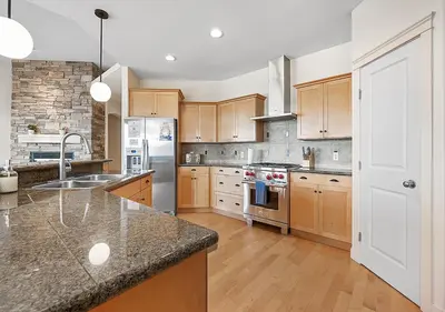 a large kitchen with wooden cabinets and stainless steel appliances at Full House with Amazing Okanagan Views and Hot Tub in Kelowna