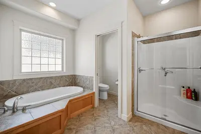 a bathroom with a tub and a shower and a toilet at Full House with Amazing Okanagan Views and Hot Tub in Kelowna