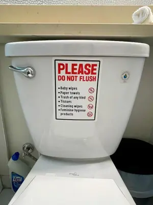a sign on the tank of a toilet that says please do not flush at Budget friendly 2-Bed 1-Bath Suite in New Westminster
