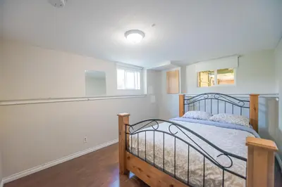 a bedroom with a bed and a window at 4 Bedroom Semi-basement Suite in Burnaby Metrotown in Burnaby