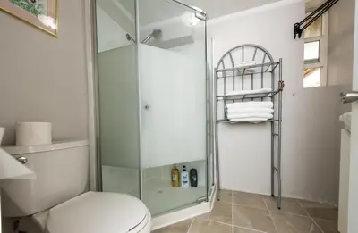 a bathroom with a toilet and a glass shower at 4 Bedroom Semi-basement Suite in Burnaby Metrotown in Burnaby