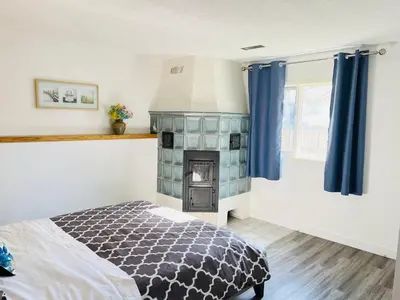 a bedroom with a fireplace and a bed with blue curtains at Entire 6BED house easy to Banff & DT, Winsport in Calgary