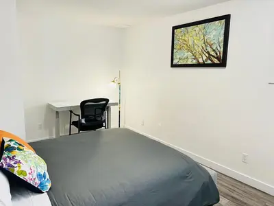a bedroom with a bed and a desk and a chair at Entire 6BED house easy to Banff & DT, Winsport in Calgary