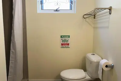 a small bathroom with a toilet and a window at Entire 6BED house easy to Banff & DT, Winsport in Calgary