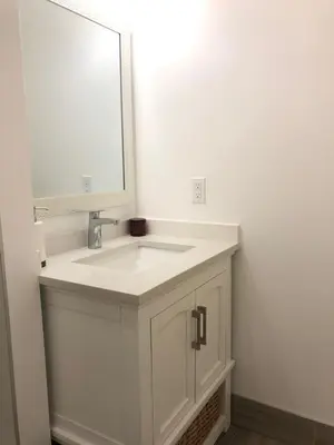 a bathroom with a white sink and a mirror at Entire 6BED house easy to Banff & DT, Winsport in Calgary