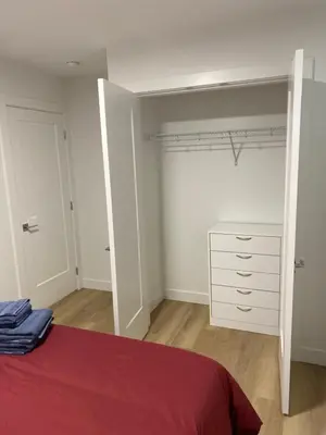 a bedroom with a red bed and a white dresser at Oceanside 2 Bedroom Suite in Royal Bay-Free Nespresso Coffee with Welcome Treats in Colwood