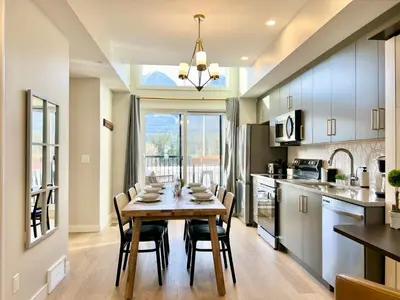 a kitchen with a table and chairs in a kitchen at Stunning View New Townhome Sleeps 11 AC and Hot Tub in Canmore