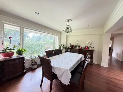 a dining room with a table and chairs and a window at Luxuary Stay in West Vancouver in West Vancouver