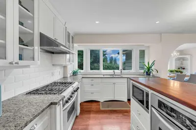 a kitchen with white cabinets and a counter top at Luxuary Stay in West Vancouver in West Vancouver