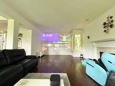 a living room with a black couch and a tv at Luxuary Stay in West Vancouver in West Vancouver