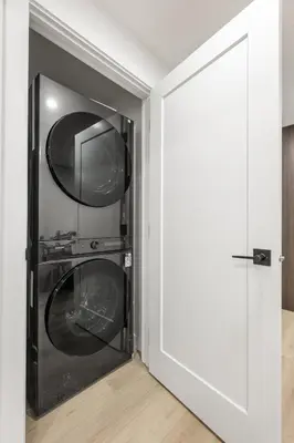 a door to a laundry room with a washer and dryer at Lake Community Hideout in Chestermere