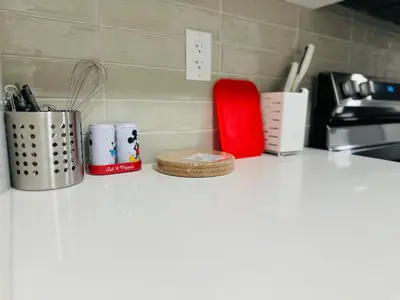 a kitchen counter with cups and utensils on it at 2 Bedroom snug retreat in Livingston Calgary Alberta in Calgary