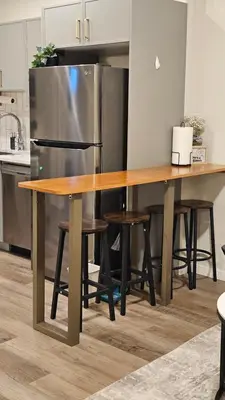 a kitchen with a wooden table and a refrigerator at Modern Suite - Separate Entry - Self Check-In in Calgary
