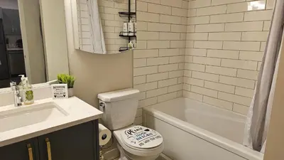 a bathroom with a toilet and a tub and a sink at Modern Suite - Separate Entry - Self Check-In in Calgary