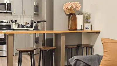 a kitchen with a counter with stools at Modern Suite - Separate Entry - Self Check-In in Calgary