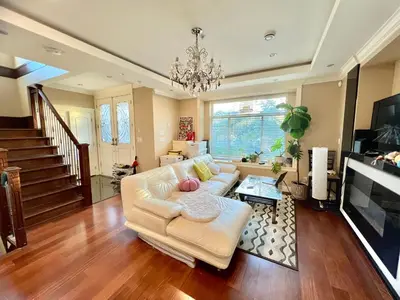 a living room with a white couch and a chandelier at Cozy stay in Cental Vancouver in Vancouver