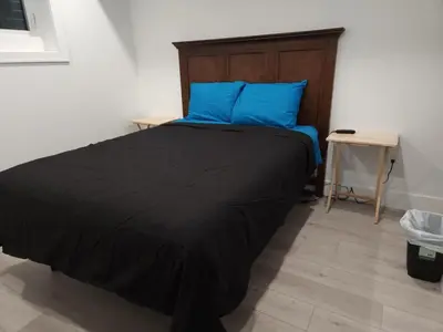 a bedroom with a bed with blue pillows and a table at vistaeast 1-Bedroom Condo Rupert st in Vancouver