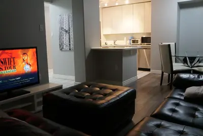a living room with a couch and a television at Wildrose : 2-Bedroom City Apartment in Calgary
