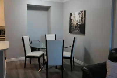 a dining room with a glass table and chairs at Wildrose : 2-Bedroom City Apartment in Calgary
