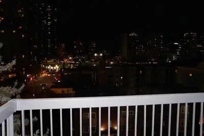 a view of a city at night from a balcony at Wildrose : 2-Bedroom City Apartment in Calgary