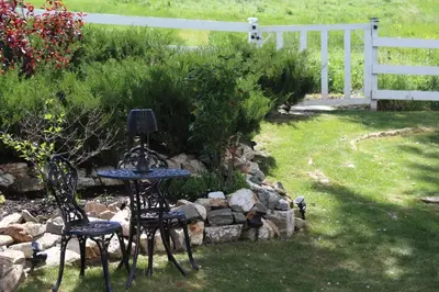 two chairs and a table in a yard at Country Cottage B&B in Vernon