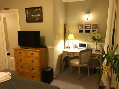 a bedroom with a desk with a laptop on a dresser at Country Cottage B&B in Vernon