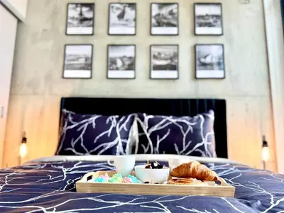 a tray of food and pastries on a bed at Elegant, Comfy & Sophisticated MetroLux Downtown Suite in Calgary