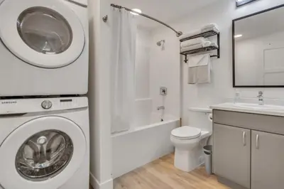 a white bathroom with a washing machine in it at Pure Paradise in Prince George