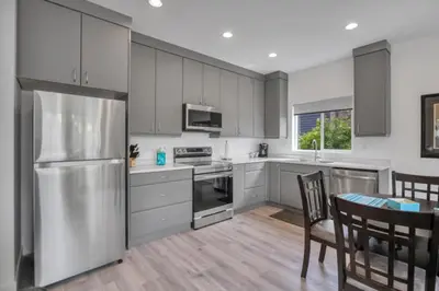 a kitchen with a stainless steel refrigerator and a table at Pure Paradise in Prince George