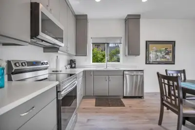 a kitchen with white appliances and a table and chairs at Pure Paradise in Prince George