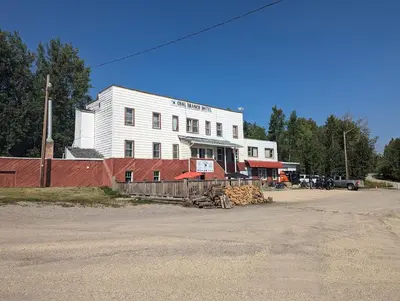 a white building with a fence in front of it at Coal Branch Hotel & Restaurant
