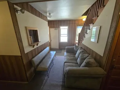 a living room with a couch and a staircase at Coal Branch Hotel & Restaurant