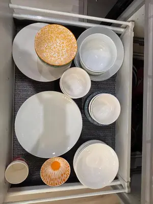 a refrigerator filled with white plates and bowls at Zillion’s Joy in Calgary