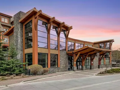 an office building with glass windows and wooden beams at Solara 2BR Retreat - Pool - Hot Tub & Resort Perks in Canmore