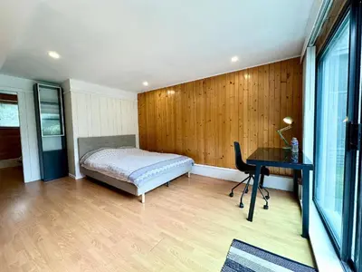 a bedroom with a bed and a desk and a table at Spacious 5 Bedroom House Near YVR Airport, Transit & Shopping in Richmond