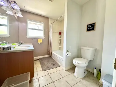 a bathroom with a toilet and a sink and a tub at Spacious 5 Bedroom House Near YVR Airport, Transit & Shopping in Richmond