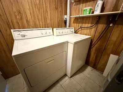 a washer and dryer in a room with wooden walls at Beautiful Place with Kitchen, Washing Machine and Internet Near YVR Airport, Transit and Shopping Mall in Richmond