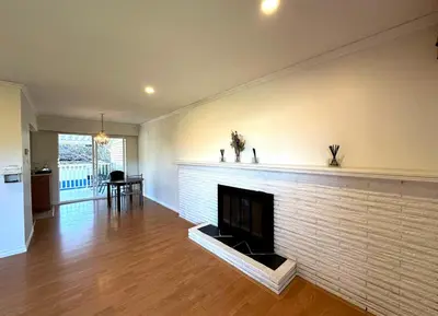 a living room with a white brick fireplace at 2 Bedrooms Garden Suite with Living Room, Kitchen and Laundry near YVR Airport, Transit and Shopping Mall in Richmond