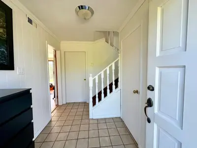 a hallway with a white door and a staircase at 2 Bedrooms Garden Suite with Living Room, Kitchen and Laundry near YVR Airport, Transit and Shopping Mall in Richmond