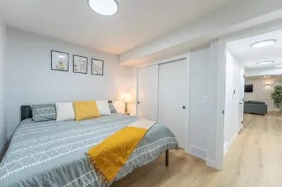 a bedroom with a bed and a white wall at New 1 bdr basement apartment in Calgary
