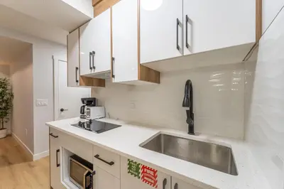 a kitchen with white cabinets and a sink at New 1 bdr basement apartment in Calgary
