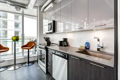 a kitchen with a sink and a dishwasher at Modern 1BR plus Den Condo for 4 guests Great Views and Balcony in Calgary