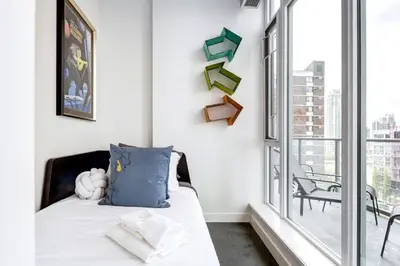 a bedroom with a bed and a large window at Modern 1BR plus Den Condo for 4 guests Great Views and Balcony in Calgary