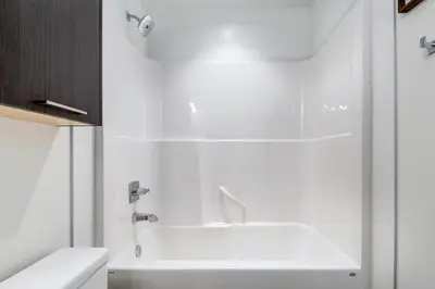 a white bathroom with a tub and a sink at Modern 1BR plus Den Condo for 4 guests Great Views and Balcony in Calgary
