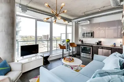 a living room with a couch and a table at Modern 1BR plus Den Condo for 4 guests Great Views and Balcony in Calgary